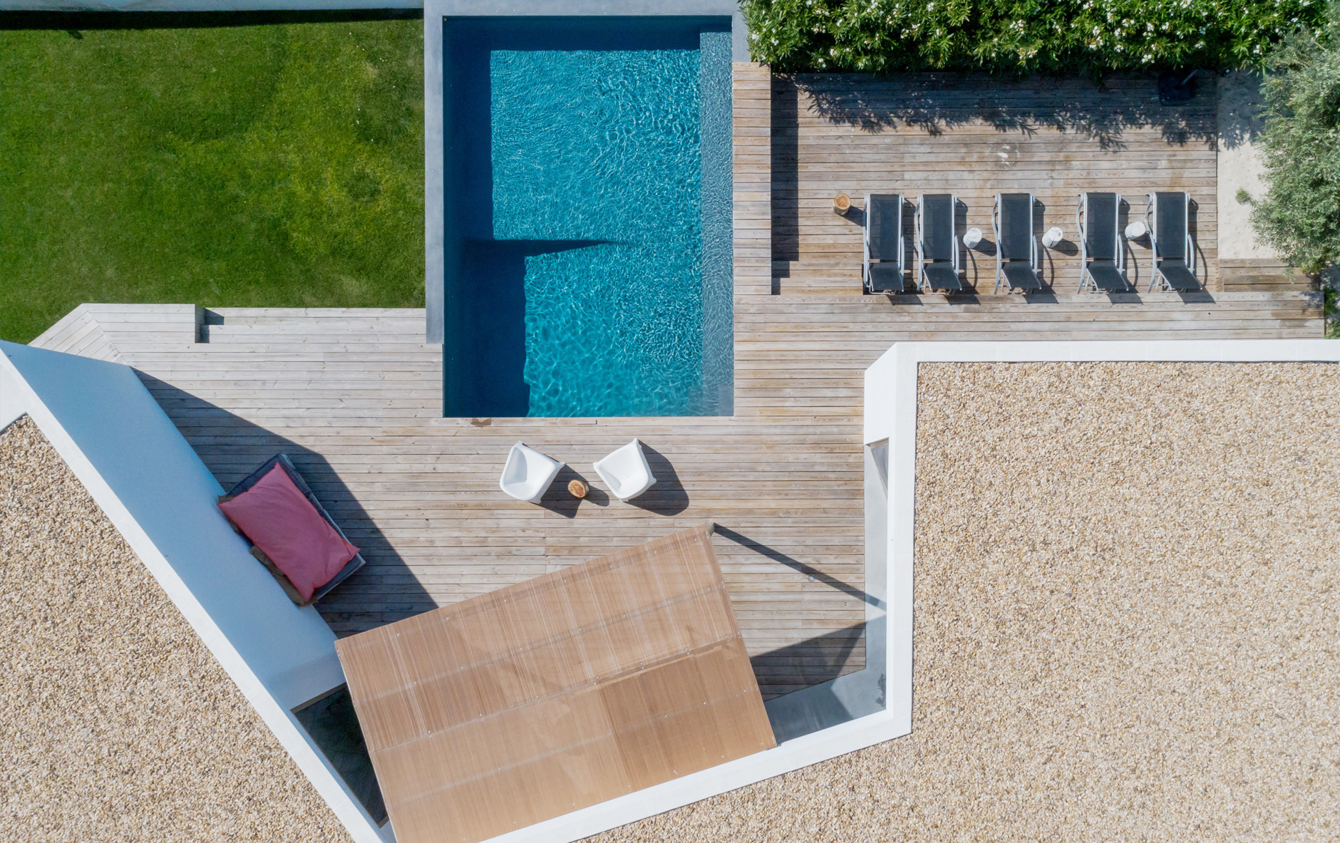 External view of stylish family house with fence, garage, stone driveway and garden, panorama